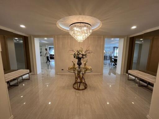 Spacious entrance hallway with chandelier and decorative table