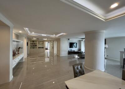 Spacious modern living room with built-in shelves, recessed lighting, and polished flooring
