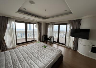 Spacious bedroom with large windows and balcony