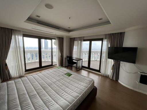 Spacious bedroom with large windows and balcony