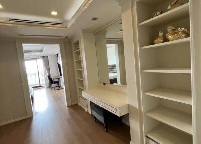 Spacious living area with built-in shelving and large mirror