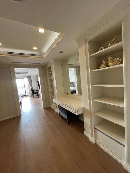 Spacious living area with built-in shelving and large mirror