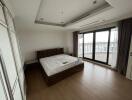 Spacious bedroom with large windows and balcony access