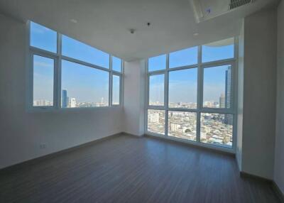 Bright and spacious living room with large windows offering a city view