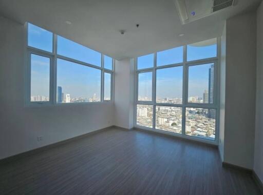 Bright and spacious living room with large windows offering a city view