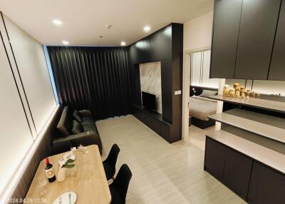 modern living and dining area with a visible bedroom