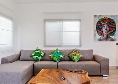 Modern living room with a sectional sofa, wooden coffee table, and artwork on the wall