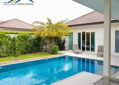 Outdoor swimming pool with adjacent patio and greenery