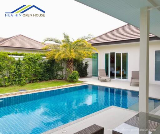 Outdoor swimming pool with adjacent patio and greenery