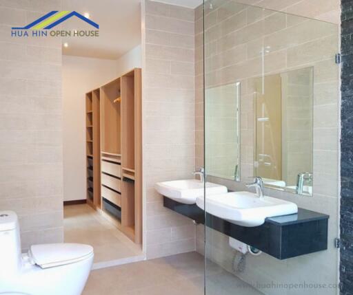 Contemporary bathroom with double sinks and glass shower enclosure