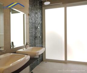 Modern bathroom with double sinks and walk-in shower