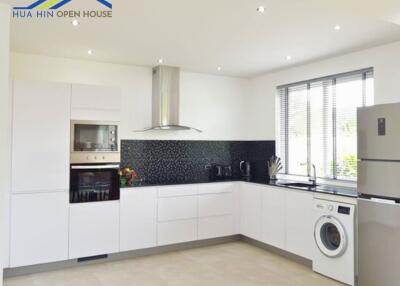 Modern kitchen with white cabinets and appliances