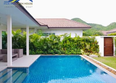 Outdoor pool area with seating and lush greenery