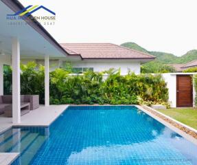 Outdoor pool area with seating and lush greenery