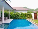 Outdoor pool area with seating and lush greenery