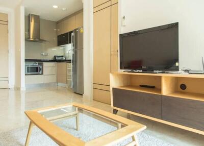 Modern living room with kitchen area, TV, and coffee table