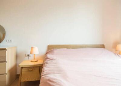 Cozy bedroom with wooden furniture and pink bedding