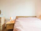 Cozy bedroom with wooden furniture and pink bedding