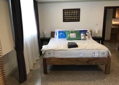 A neatly arranged bedroom with a wooden bedframe, bedside tables, and modern decor.