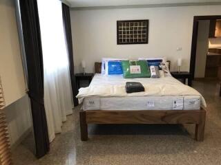 A neatly arranged bedroom with a wooden bedframe, bedside tables, and modern decor.