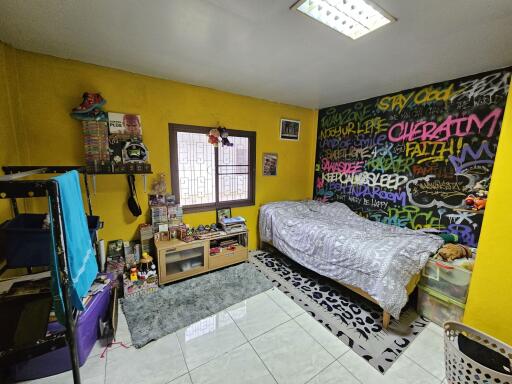 Colorful bedroom with graffiti wall, single bed, and window