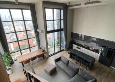 Modern loft living room with large windows and city view