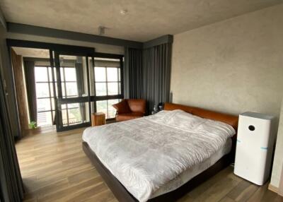 Spacious bedroom with large bed, wooden floors, and modern decor