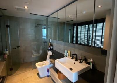 Modern bathroom with glass shower, large mirror, and single sink