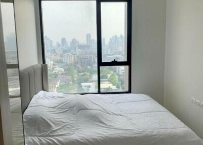 Bedroom with large window and city view