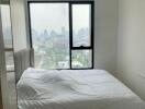 Bedroom with large window and city view