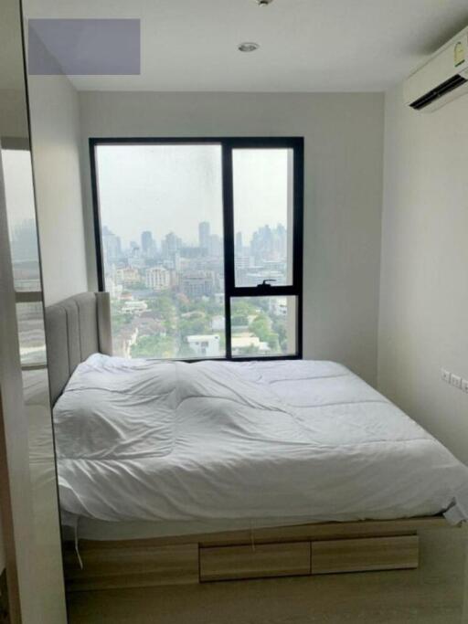 Bedroom with large window and city view