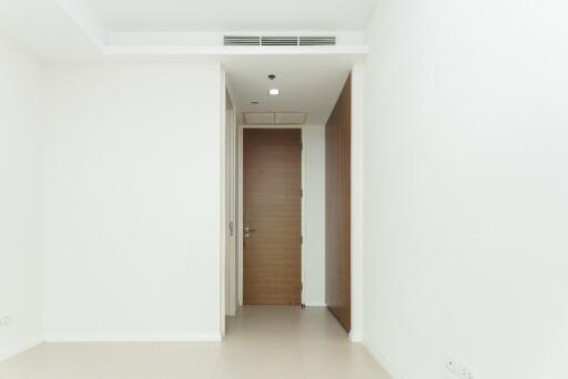 Minimalist hallway with white walls and a wooden door