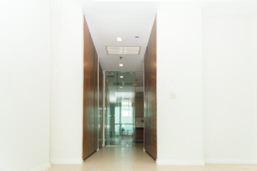 Bright hallway with wooden cabinets and glass door