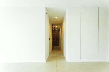 Bright hallway with white walls and tiled flooring