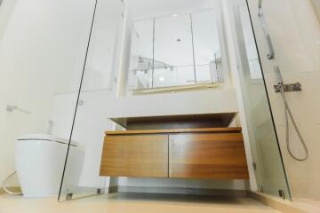 Modern bathroom with glass shower doors and wooden vanity