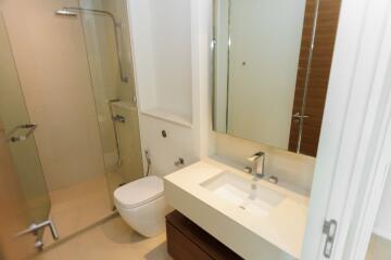 Modern bathroom with glass shower, toilet, and sink