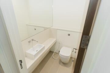 Small bathroom with white sink, toilet and large mirror