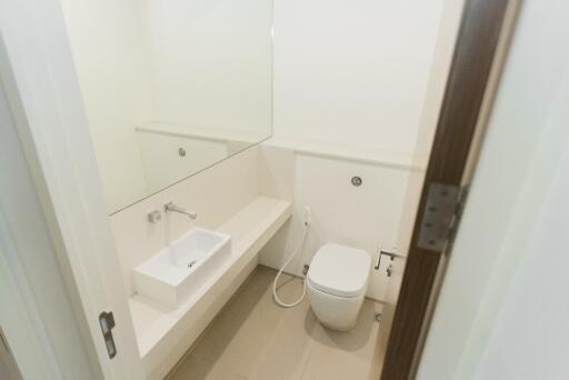 Small bathroom with white sink, toilet and large mirror