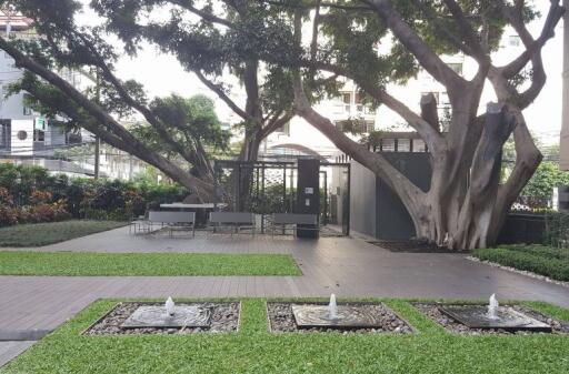 Green garden area with fountains and seating