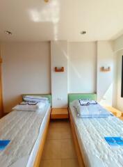 Two beds in a bright bedroom with natural lighting