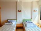 Two beds in a bright bedroom with natural lighting