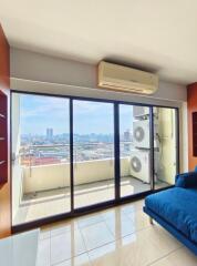 Living room with large glass doors leading to a balcony, city view