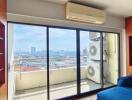 Living room with large glass doors leading to a balcony, city view