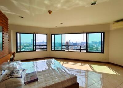 Bright bedroom with large corner windows and city view