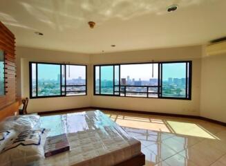 Bright bedroom with large corner windows and city view