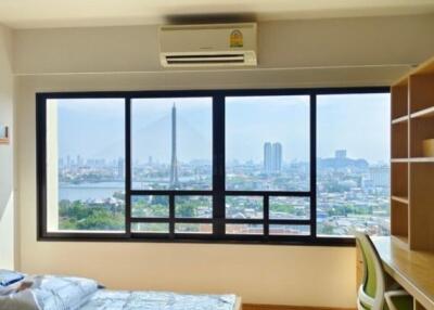 Brightly lit bedroom with large window and city view