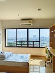 Brightly lit bedroom with large window and city view