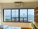 Brightly lit bedroom with large window and city view