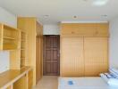 Spacious bedroom with built-in wooden shelves and closets