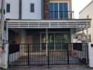 Two-story residential building with gated entrance